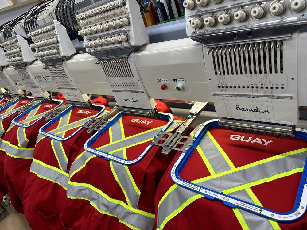 Parkas haute visibilité Grue Guay en cours de broderie sur les machines Barudan de B2M à Lévis
