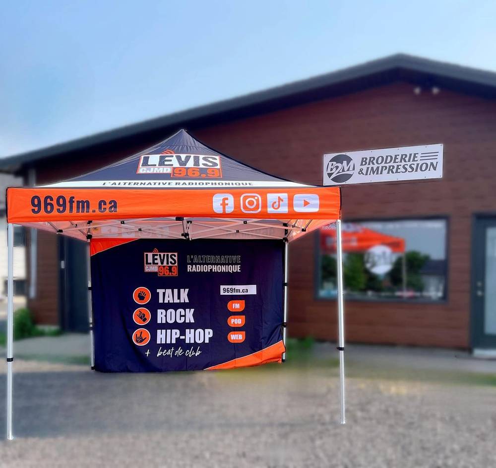 Tente pop-up imprimée pour la radio CJMD Lévis 96,9, devant l'atelier B2M